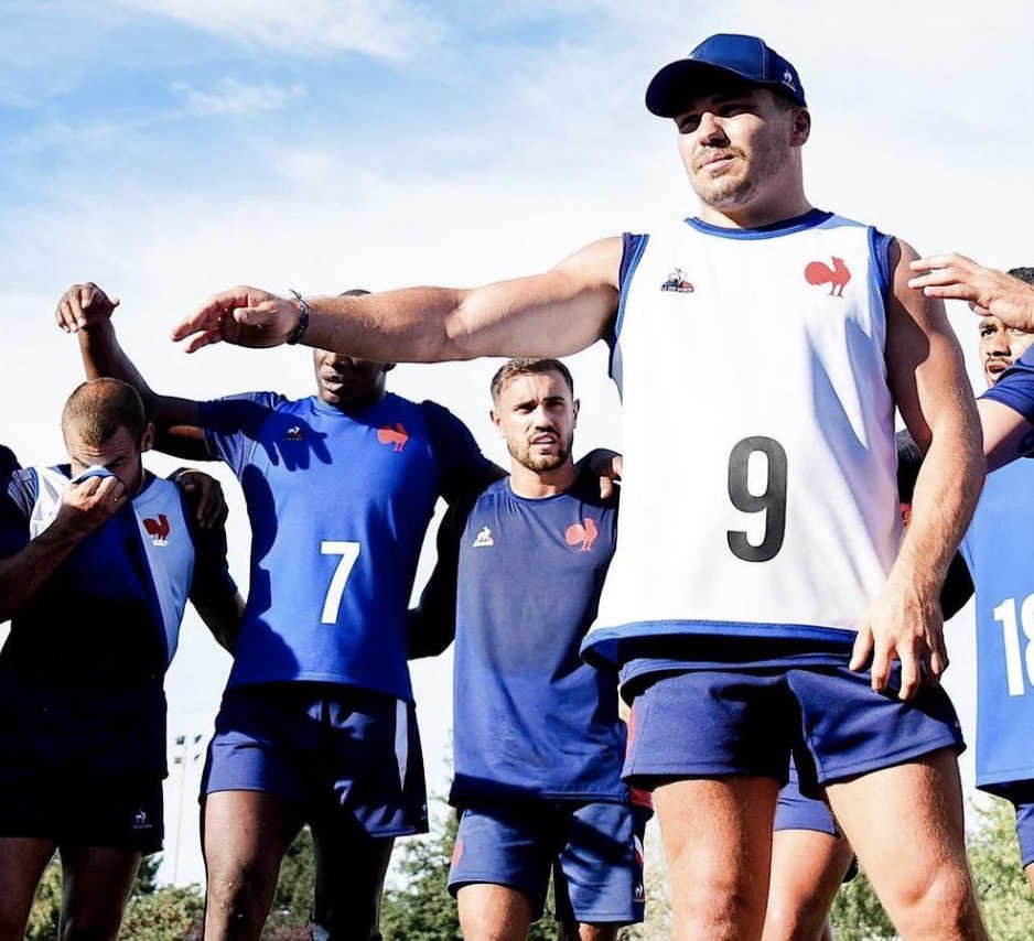 Antoine Dupont qui s’apprête à faire un cris de guerre avec ses coéquipiers en équipe de France de rugby avant la coupe du monde