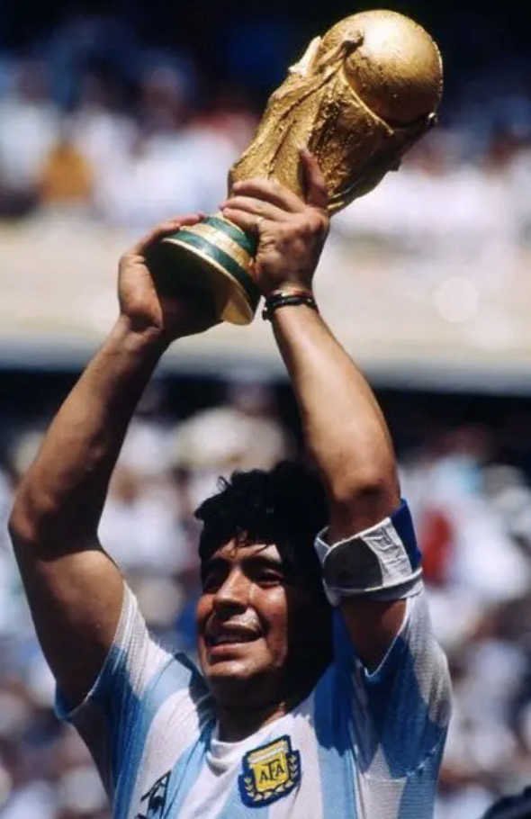 Diego Maradona célèbre la Coupe du Monde 1986 trophée en mains 