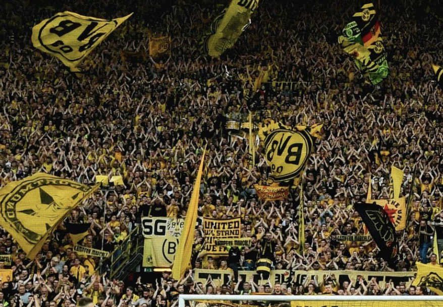 Les supporters du Borussia Dortmund en tribunes avec des drapeaux 
