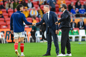 Le sélectionneur australien Joe Schmidt serre la main du Français Matthieu Jalibert sous le regard de son homologue français Fabien Galthié